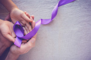 Purple ribbon in peoples hands
